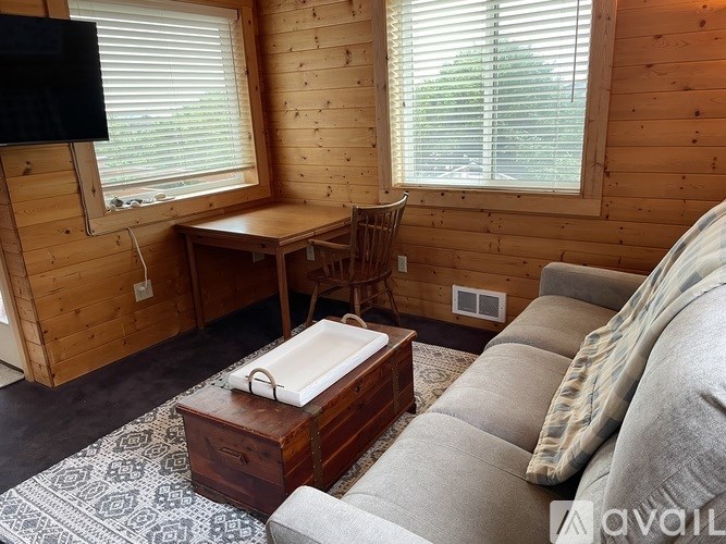 A cozy living room with a couch, a coffee table, and a television.