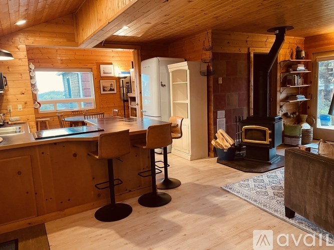 A kitchen with wooden cabinets and a bar area.