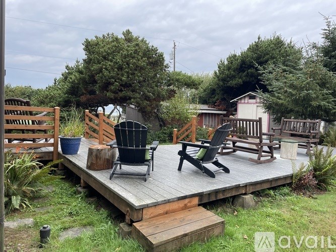 A wooden deck with chairs and a table.