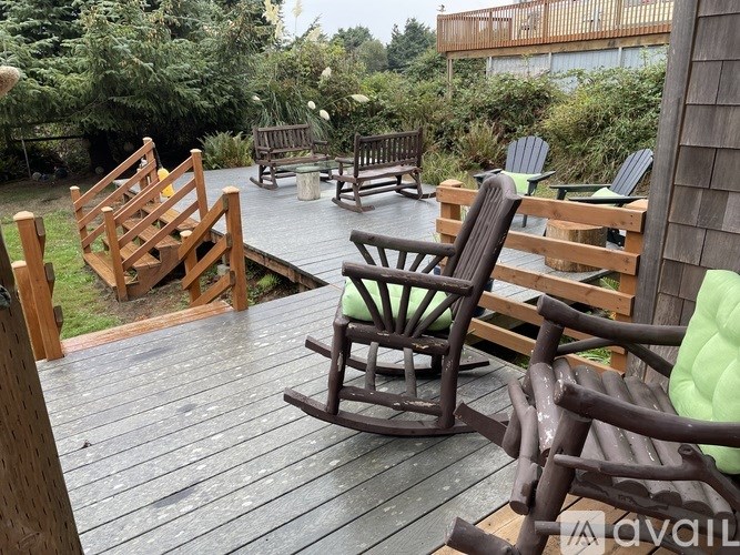 A wooden deck with chairs and a bench.