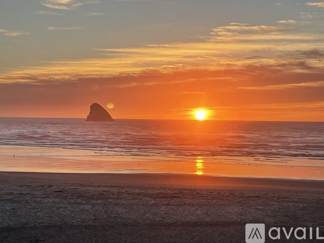 A beautiful sunset over the ocean with a small island in the distance.