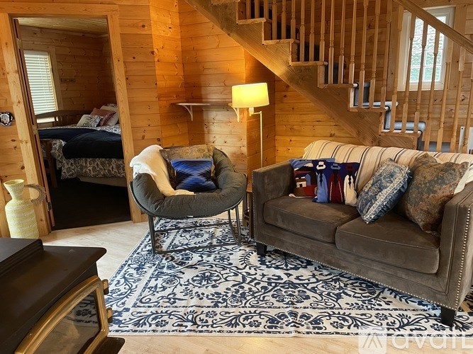 A cozy living room with a couch, chair, and a rug.