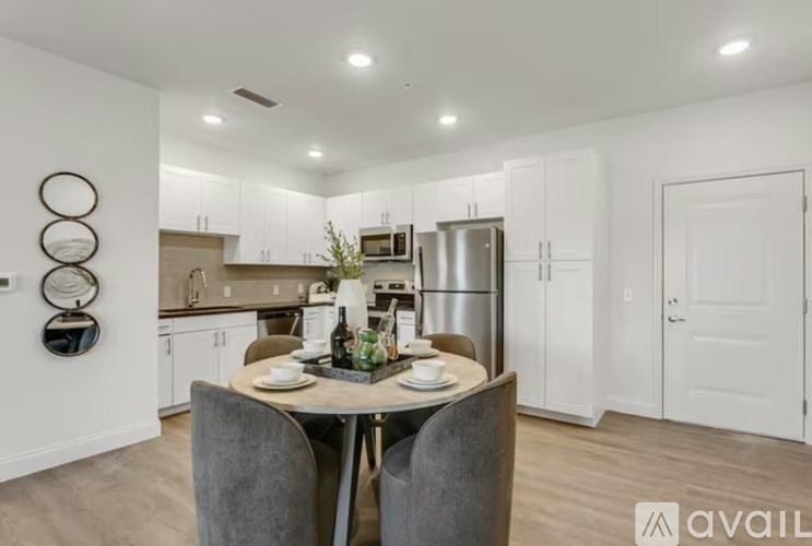 A modern kitchen with a dining table set for two.