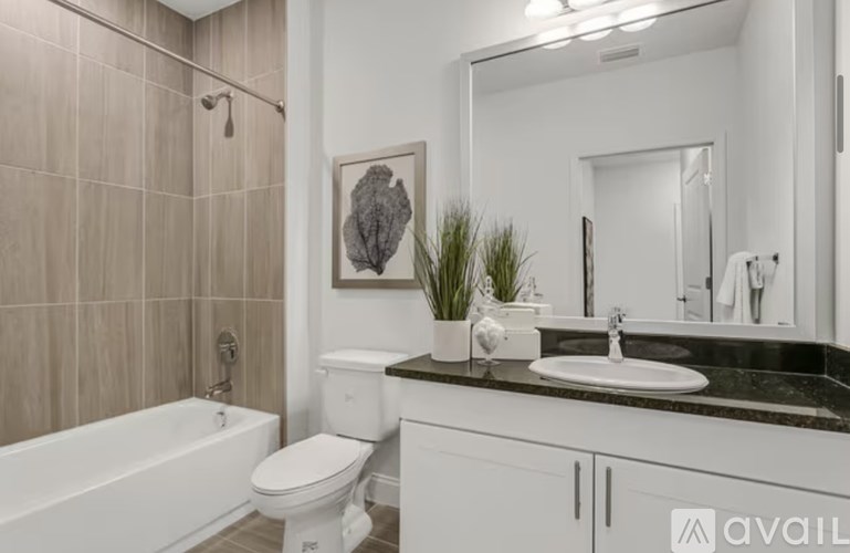 A bathroom with a white tub, toilet, and sink.