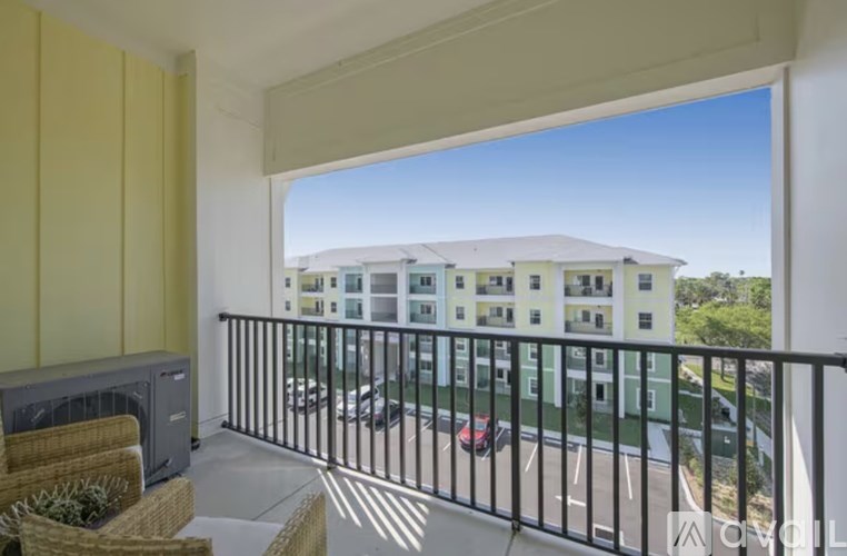 A balcony with a view of a building and cars.