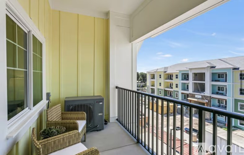 A balcony with a table and chairs overlooks a building.
