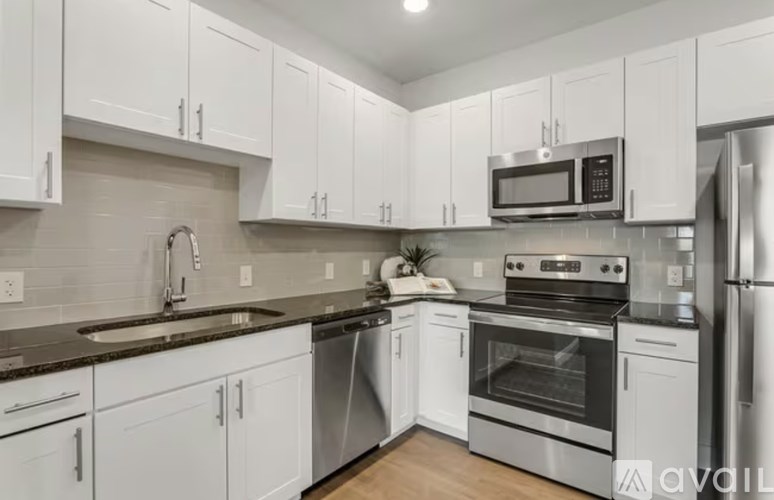 A kitchen with white cabinets and stainless steel appliances.