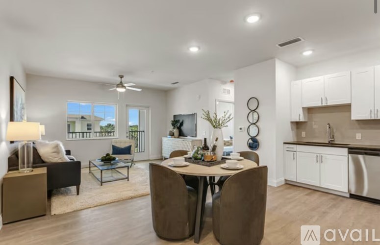 A modern dining room with a table set for two and a view of the balcony.