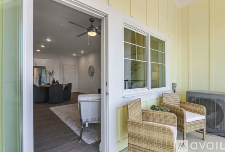 A living room with a white sofa and a fan.