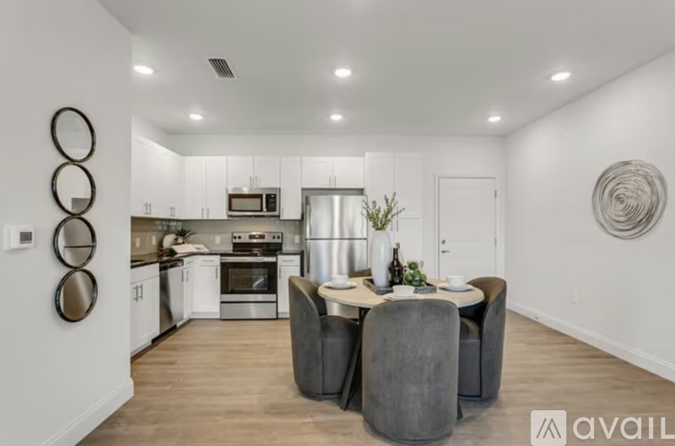 A modern kitchen with a dining table set for two.