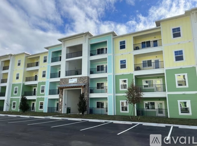 A multi-story apartment building with a parking lot in front.