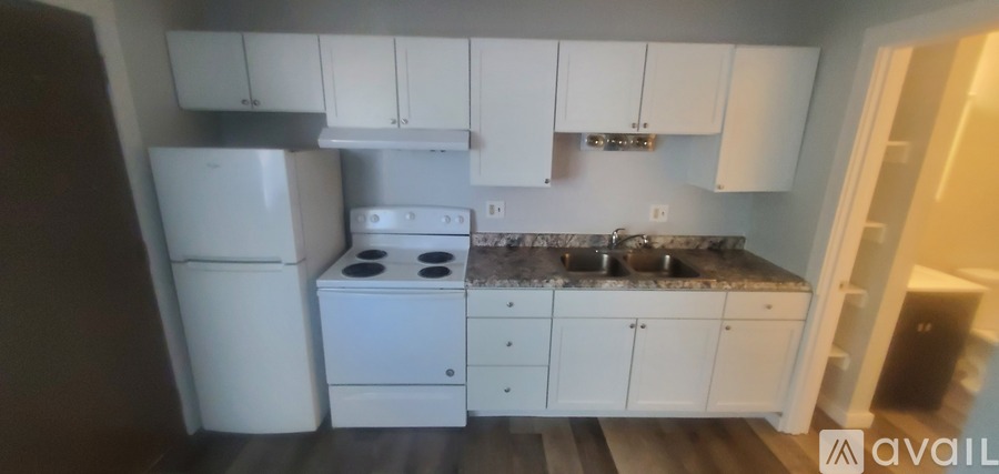 A kitchen with white appliances and cabinets.