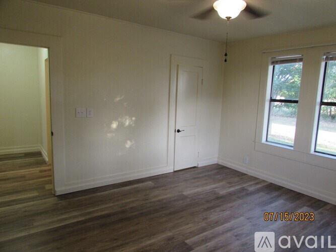 A room with wooden floors and a ceiling fan.