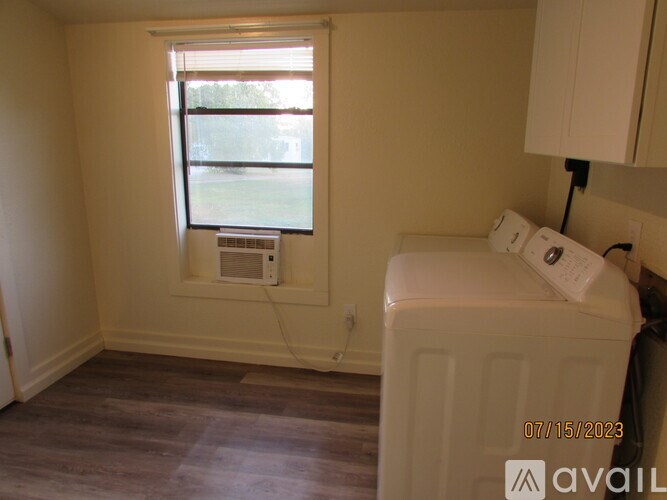 A small bedroom with a window and a microwave.