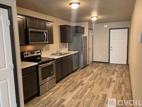 A kitchen with black cabinets and stainless steel appliances.