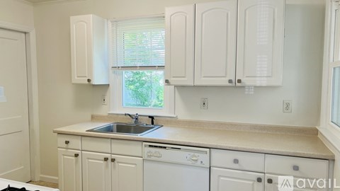 A kitchen with white cabinets and appliances.