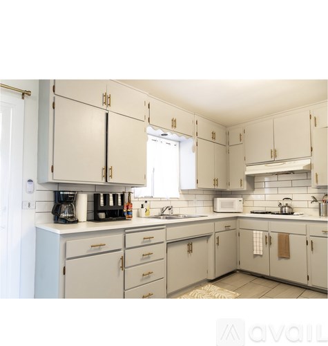 A kitchen with white cabinets and a white counter top.