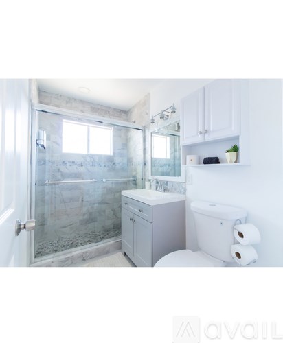 A bathroom with a toilet, sink, and shower.