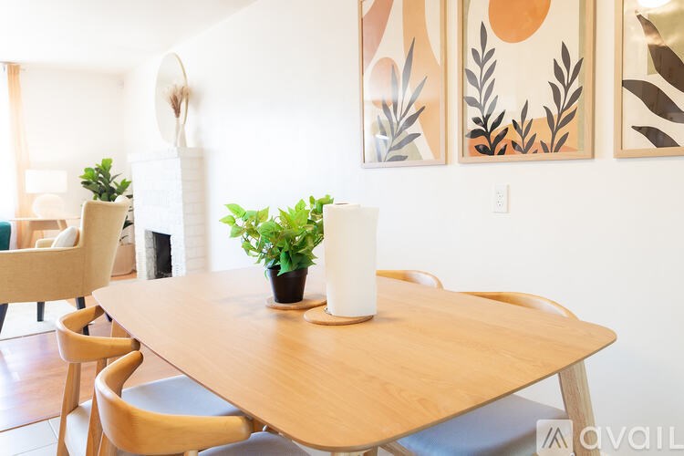 A wooden table with a white candle and a plant on it.