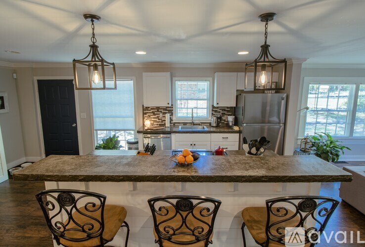 A kitchen with a table and chairs in the foreground and a refrigerator in the background.