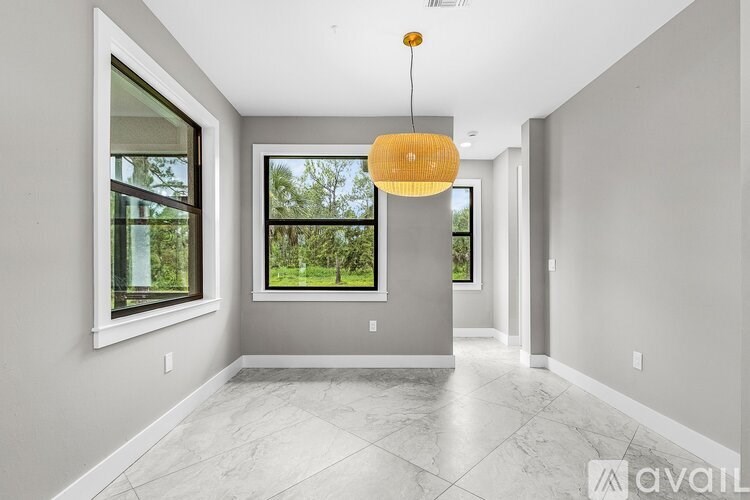 A modern room with a large window and a hanging light fixture.