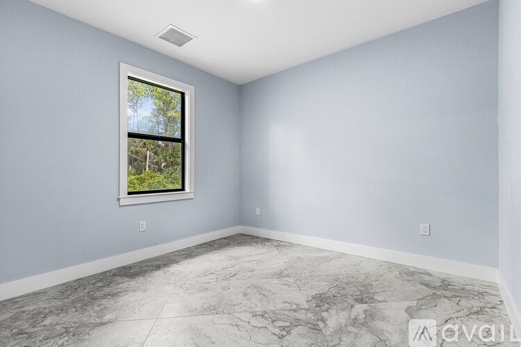 A room with a marble floor and a window showing trees outside.