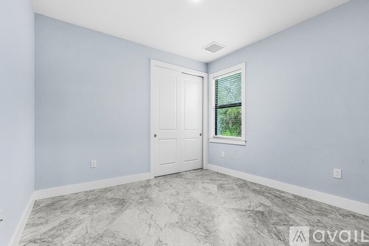 A room with a marble floor and a door leading to a window.