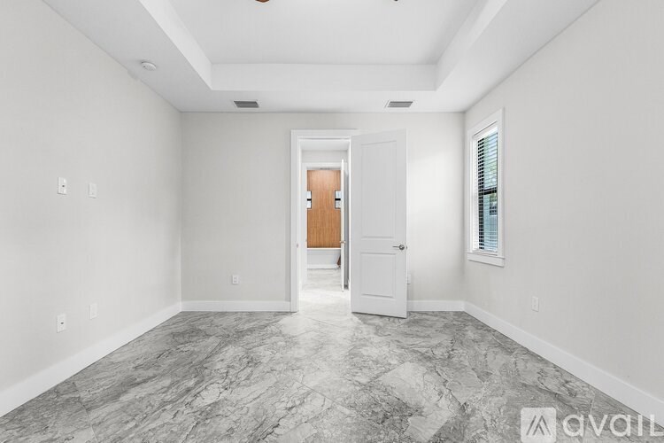 A room with a marble floor and a door in the middle.