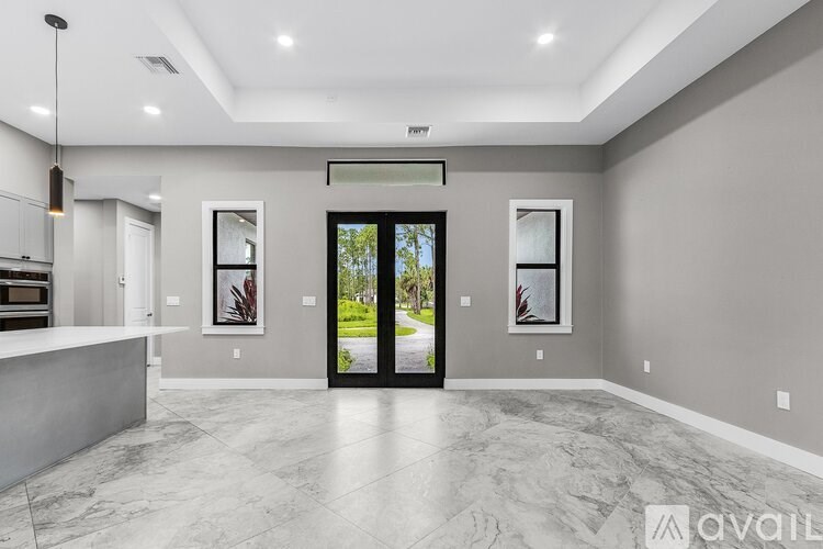 A modern kitchen with a marble floor and a large window.