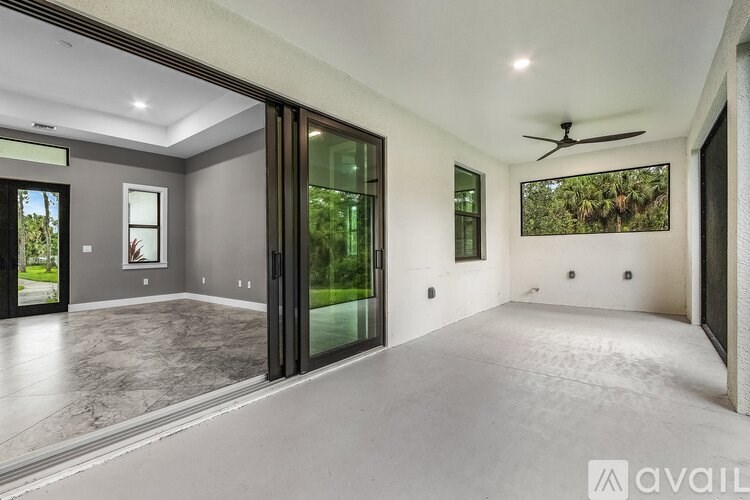A spacious room with a ceiling fan and sliding glass doors.