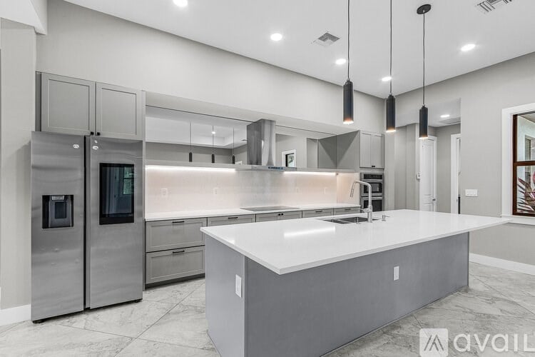 A modern kitchen with a large island and stainless steel appliances.