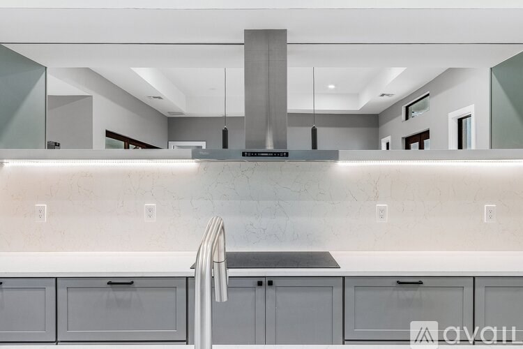 A modern kitchen with a stainless steel range hood above the stove.