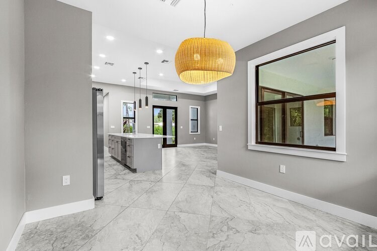 A modern kitchen with a marble floor and a hanging light fixture.