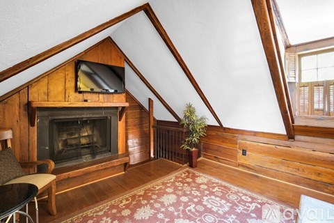 A living room with a fireplace and a television mounted above it.