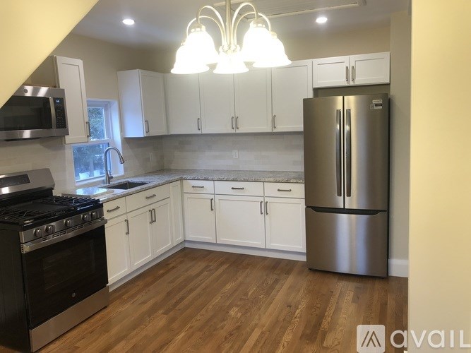 A kitchen with white cabinets and a stainless steel refrigerator.