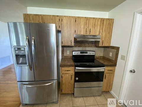 A kitchen with a stainless steel refrigerator and a stove top oven.