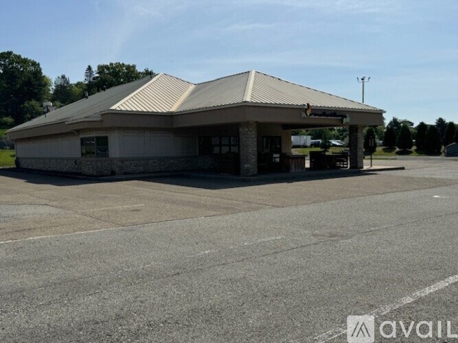 A small building with a parking lot in front.