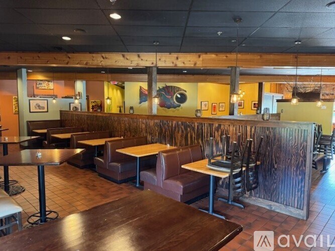 A restaurant with wooden tables and chairs and a wooden wall.