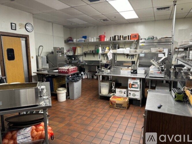 A kitchen with a lot of counter space and a clock on the wall.