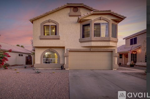 A house with a garage and a driveway in front of it.