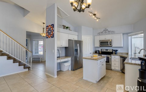 A kitchen with white cabinets and a tiled floor.