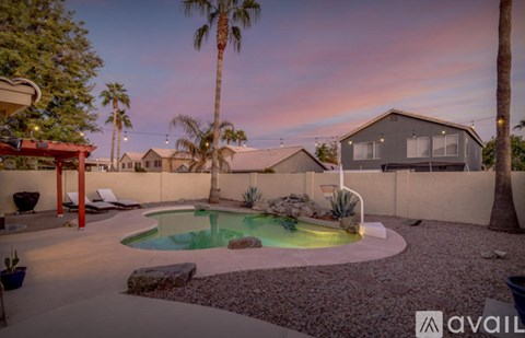 A backyard with a pool and a patio area.