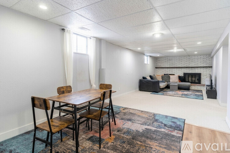 A spacious room with a fireplace and a brick wall.