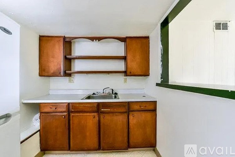A kitchen with wooden cabinets and a white countertop.
