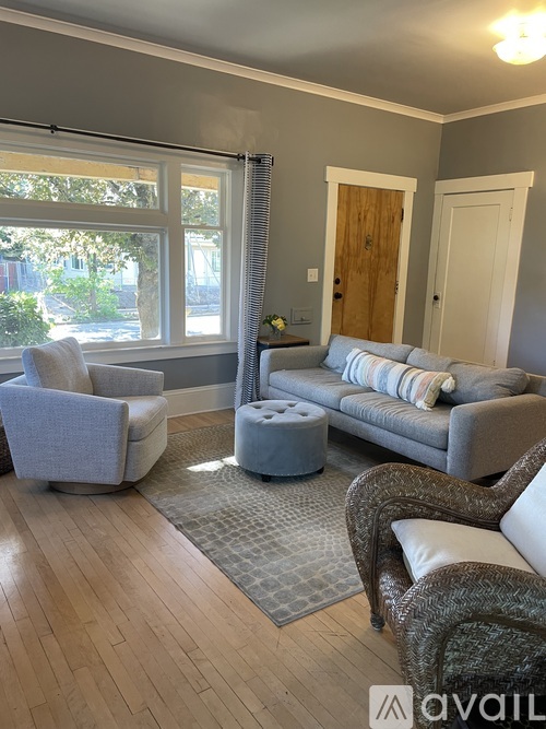A living room with a grey sofa, a grey armchair, and a grey ottoman.