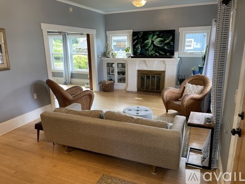A living room with a grey couch and two chairs.