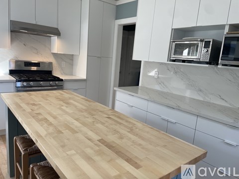 A kitchen with a wooden countertop and a stove top oven.