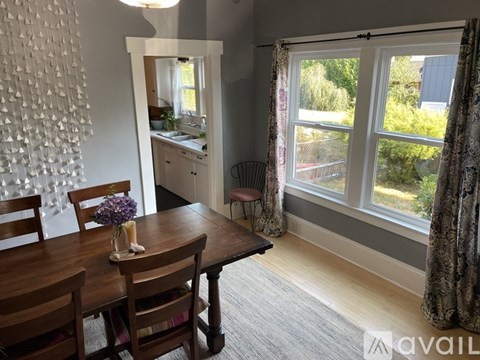 A dining room with a wooden table and chairs.
