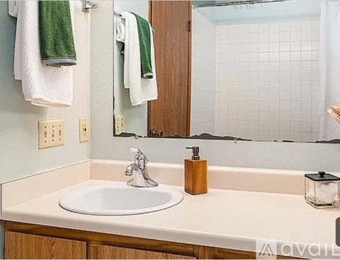 A bathroom sink with a wooden soap holder and a mirror above it.