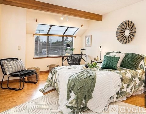 A bedroom with a large bed and a chair.